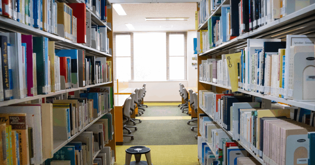 desks and chairs in library framed by two bookshelves