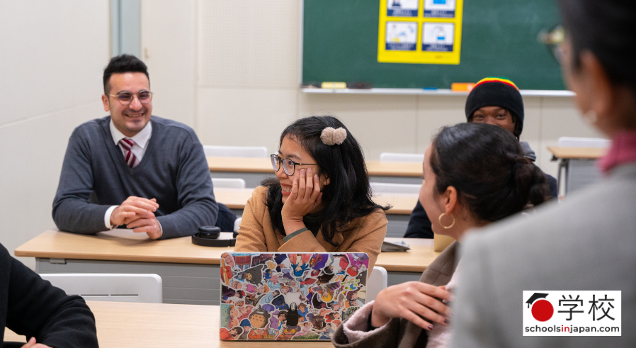 group of students sitting in a classroom talking and smiling