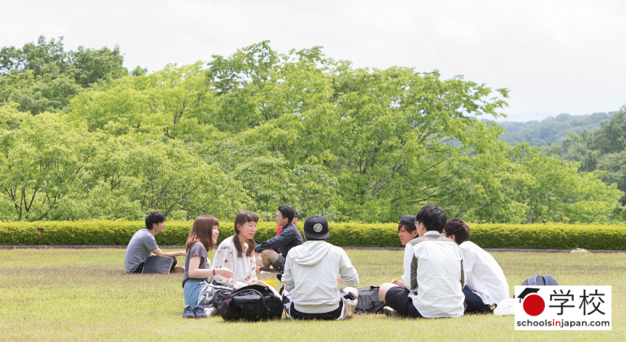 groups of students sitting and chatting on the grass at Hosei University